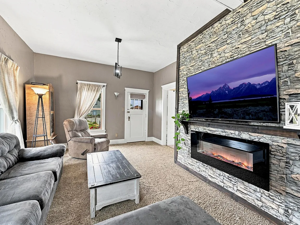 Living room with high ceiling and fireplace feature wall