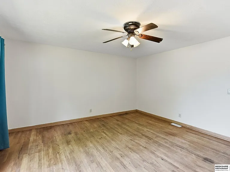 Bright bedroom with wood flooring and ceiling fan