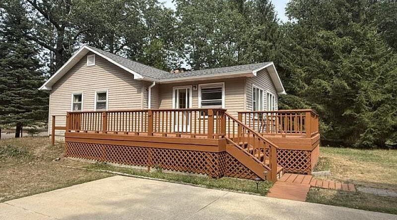 Caseville cottage with a large wraparound wood deck