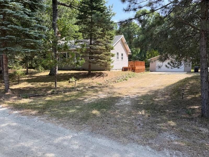 Wooded driveway showing the Caseville home and detached garage