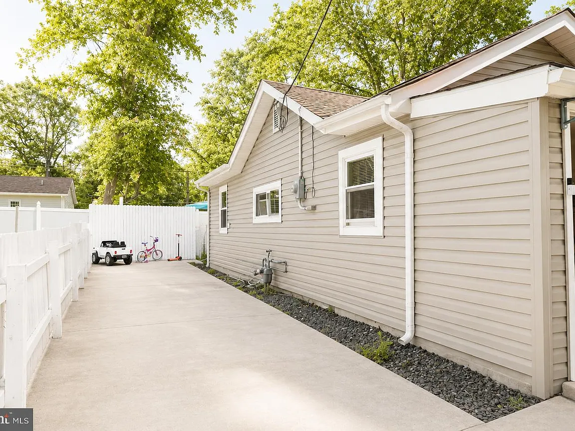 Side exterior and large concrete driveway at the Browns Mills bungalow