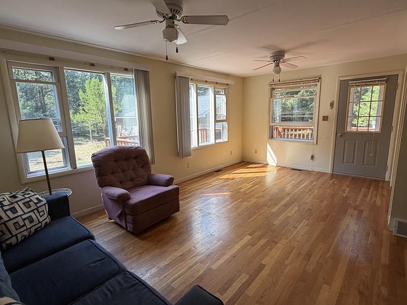 Sunny living area with hardwood floors and large windows