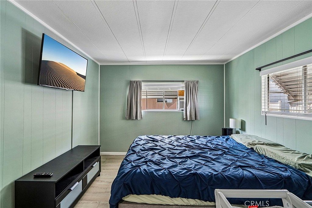 Bedroom with pale green walls and two windows