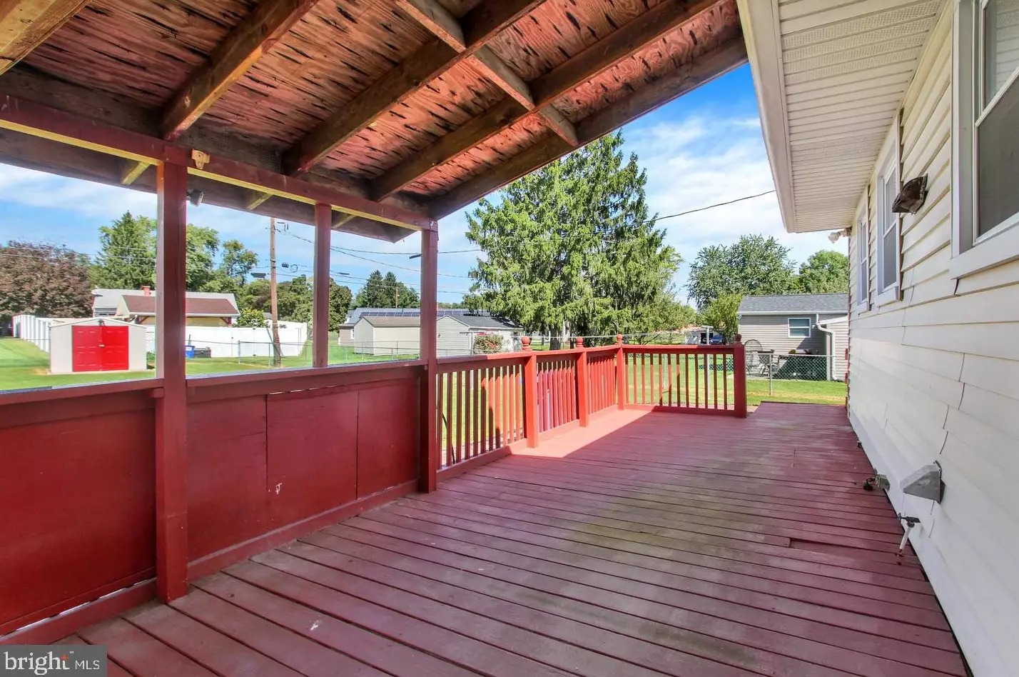 Covered rear deck overlooking the fenced yard